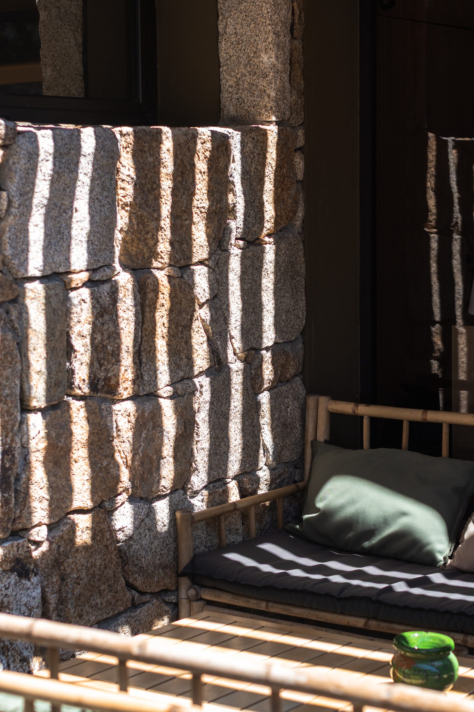 Jeu d'ombres et de lumière sur le mur de granit de la terrasse
