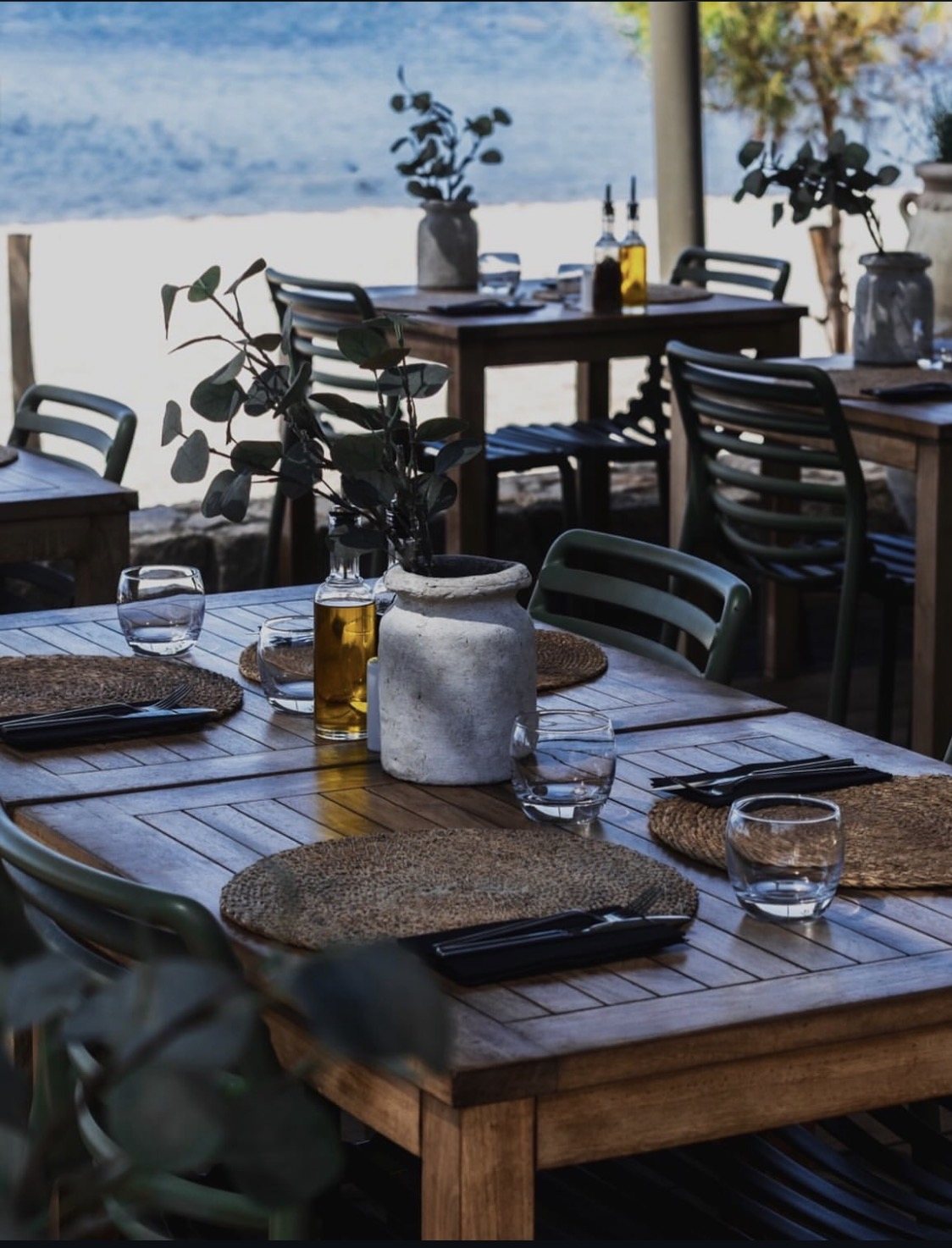Tables dressées sur la terrasse, face à la mer